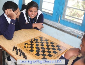 Young Indian children in school uniforms laughing and playing Chess