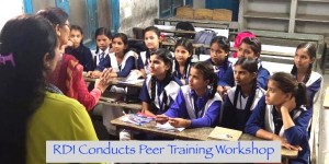 A group of Indian adolescent school children sitting in a classroom and listen to two women teachers