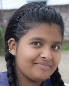An adolescent Indian girl smiles at the camera